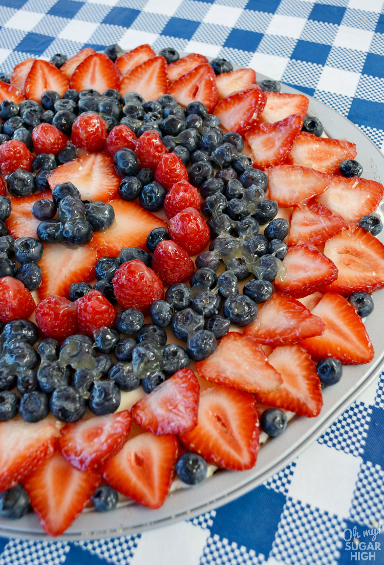This easy sugar cookie fruit pizza is topped with fresh berries and a sweet glaze. Loaded with strawberries, blueberries and raspberries, this dessert pizza makes the perfect summer treat or patriotic dessert for 4th of July, Labor Day or Memorial Day!