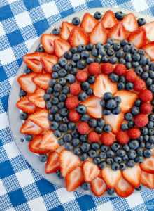 This easy sugar cookie fruit pizza is topped with fresh berries and a sweet glaze. Loaded with strawberries, blueberries and raspberries, this dessert pizza makes the perfect summer treat or patriotic dessert for 4th of July, Labor Day or Memorial Day!