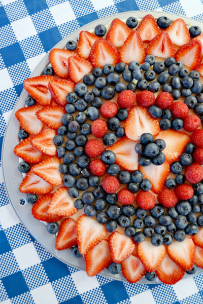 This easy sugar cookie fruit pizza is topped with fresh berries and a sweet glaze. Loaded with strawberries, blueberries and raspberries, this dessert pizza makes the perfect summer treat or patriotic dessert for 4th of July, Labor Day or Memorial Day!