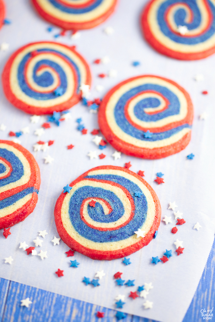 Patriotic pinwheel cookies are the perfect red, white and blue dessert for your holiday celebrations. These pinwheel cookies feature layered sugar cookie dough that is rolled with parchment paper, chilled and sliced before baking. If you want beautiful 4th of July cookies that are easy to transport and serve, try this soft pinwheel cookie recipe!