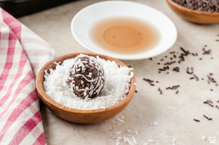 Rum balls being dipped in coconut