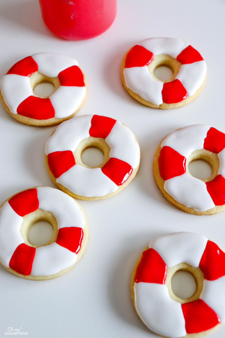Life preserver cookies work great for a beach or shark themed birthday party! These easy sugar cookies use either your favorite sugar cookie recipe or purchased refrigerated cookie dough and are decorated using royal icing. You will be surprised how easy it is to make your own shark birthday or shark week decorated cookies!