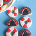 Shark Cookies!! Throwing a Shark birthday party? Make your own shark cookies with these step-by-step instructions using purchased refrigerated cookie dough or your favorite sugar cookie recipe. These shark mouth cookies are sure to take a bite out of your kids birthday celebration! Pair them with life preserver cookies and you've got a colorful combination for your dessert table.